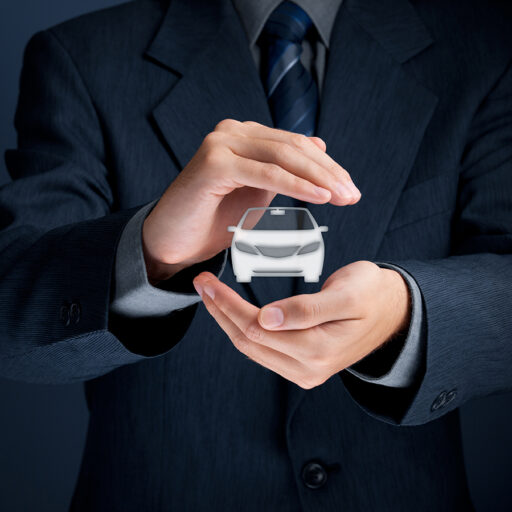 Man in a suit holding a floating white car between his palms